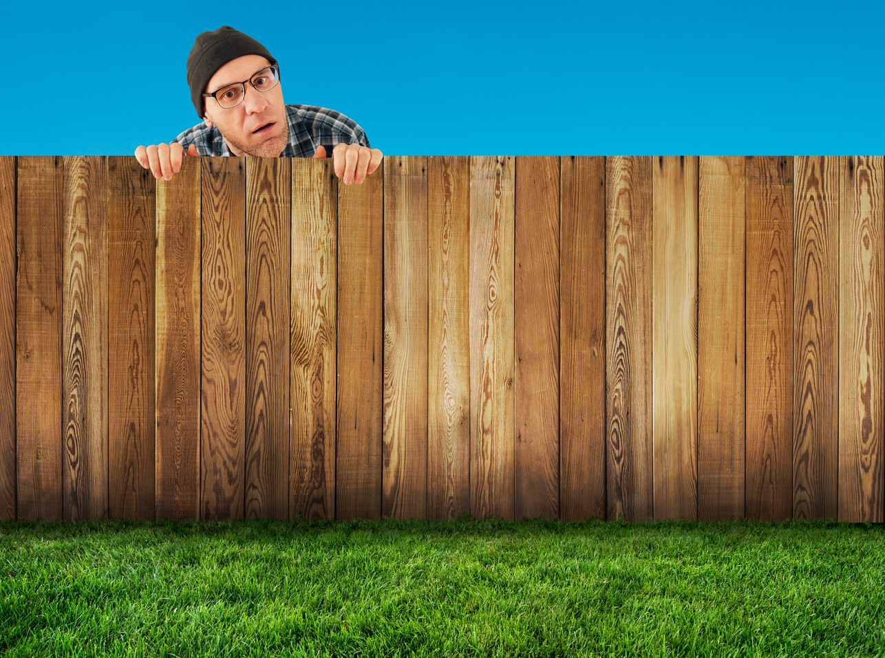 Neighbor looking over short wooden fence